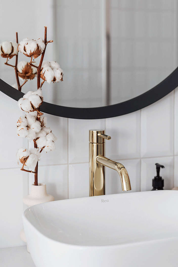 Freestanding bathtub with gold fixtures in a luxury bathroom